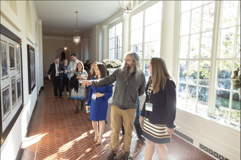 Christopher Bartlo leading a group of people through a hallway.